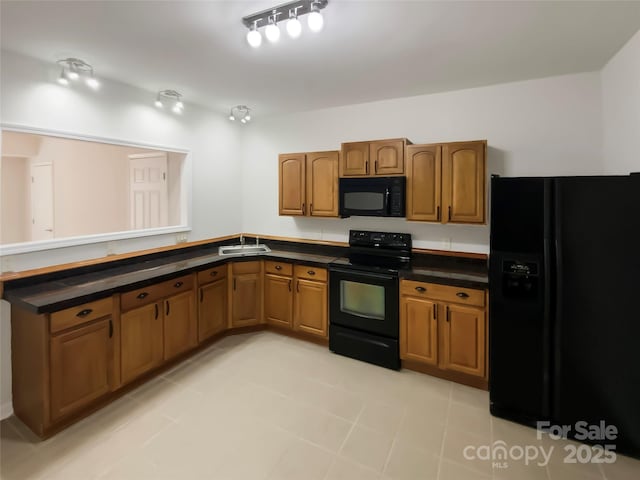 kitchen featuring brown cabinets, dark countertops, black appliances, and a peninsula