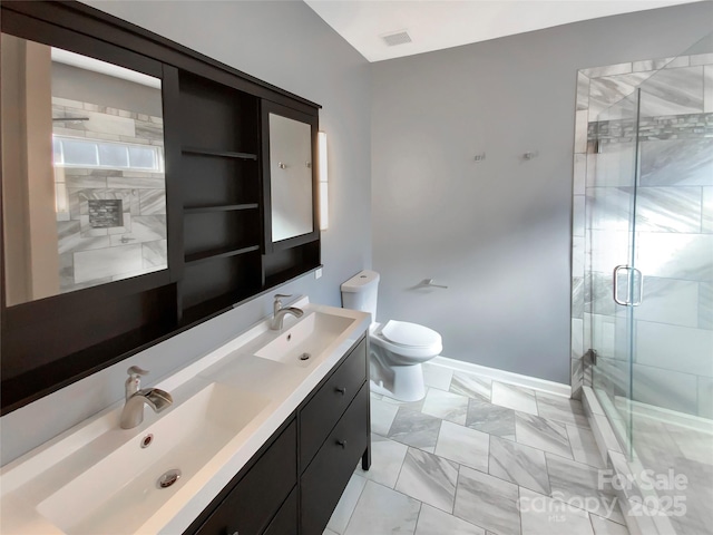 bathroom with a shower stall, toilet, double vanity, and a sink