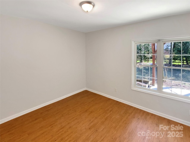 unfurnished room featuring wood finished floors and baseboards