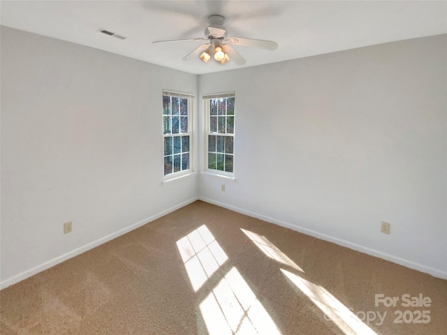 empty room featuring carpet flooring, baseboards, visible vents, and ceiling fan