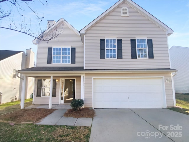 traditional home featuring a porch, concrete driveway, and a garage