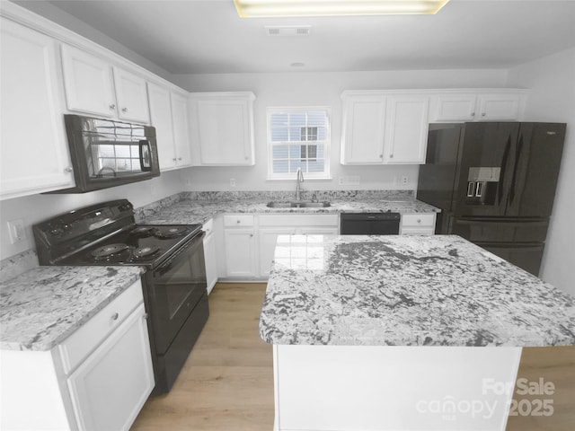 kitchen featuring a sink, white cabinetry, black appliances, and light wood finished floors