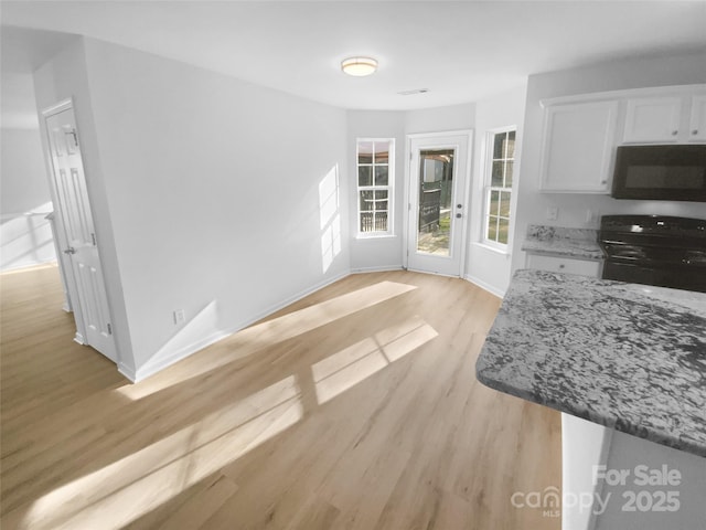 unfurnished dining area with visible vents, baseboards, and light wood-style flooring