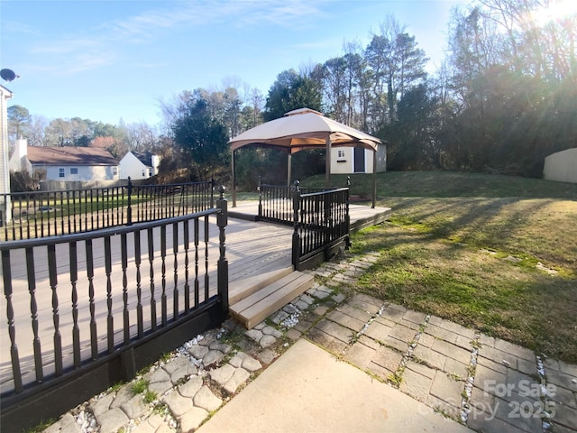 wooden terrace featuring a gazebo and a yard