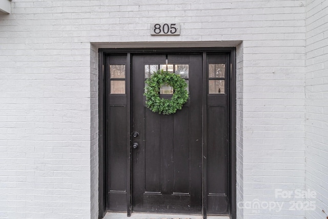 entrance to property featuring brick siding