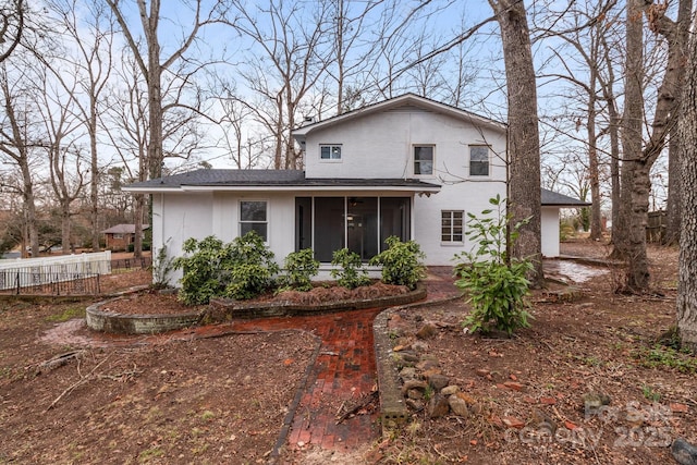 back of property with fence and a sunroom