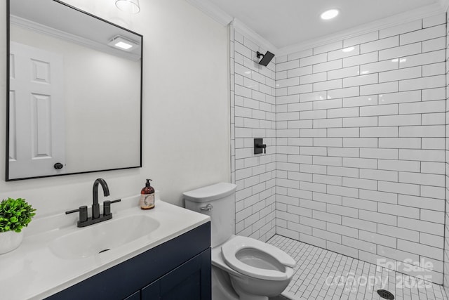 full bath featuring tiled shower, toilet, vanity, and ornamental molding