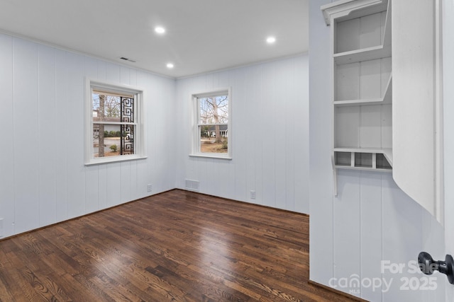 empty room with recessed lighting, dark wood-style floors, and visible vents