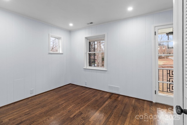 empty room featuring visible vents and dark wood-type flooring