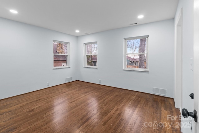 empty room with visible vents, recessed lighting, and wood finished floors