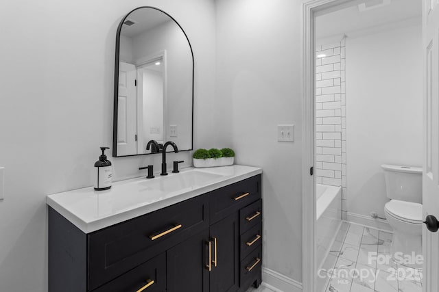 bathroom with marble finish floor, toilet, vanity, and baseboards