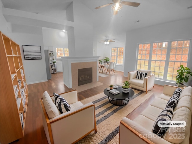 living area featuring a fireplace, wood finished floors, visible vents, and a wealth of natural light