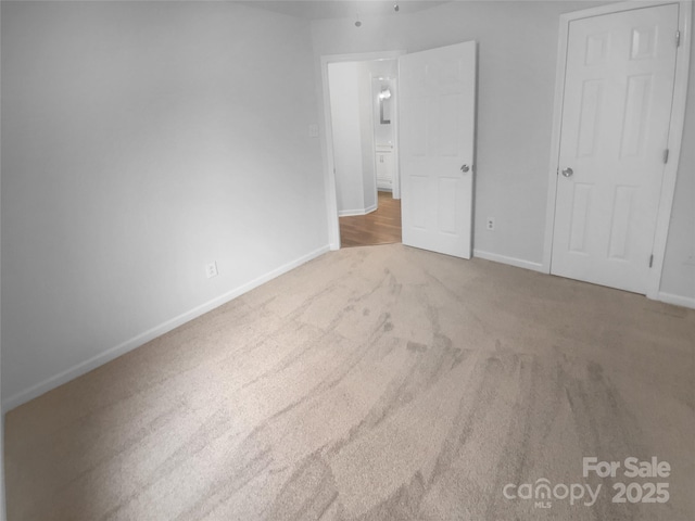 unfurnished bedroom featuring carpet and baseboards