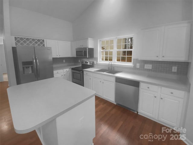 kitchen featuring a sink, high vaulted ceiling, appliances with stainless steel finishes, and white cabinetry