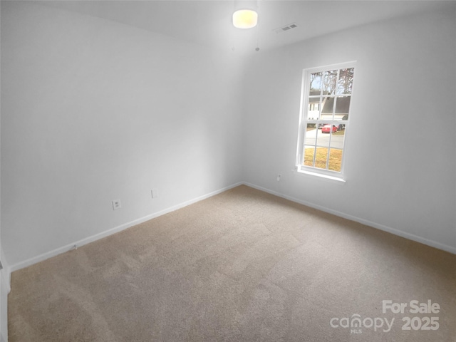 carpeted empty room with visible vents and baseboards