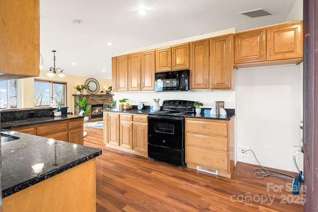 830 Fortescue Rd, Zirconia, NC 28790 - kitchen with wood finished floors, visible vents, dark stone counters, and black appliances
