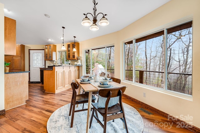 830 Fortescue Rd, Zirconia, NC 28790 - dining area featuring plenty of natural light, wood finished floors, visible vents, and an inviting chandelier