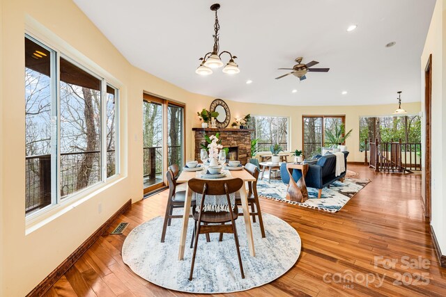 830 Fortescue Rd, Zirconia, NC 28790 - dining space with visible vents, plenty of natural light, a ceiling fan, and a stone fireplace