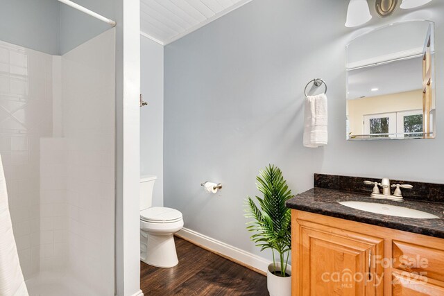 830 Fortescue Rd, Zirconia, NC 28790 - bathroom featuring wood finished floors, toilet, vanity, baseboards, and tiled shower
