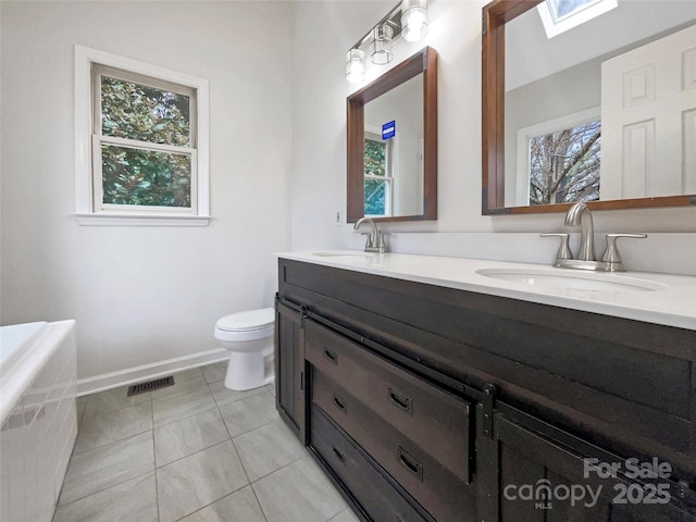 full bath featuring a sink, toilet, double vanity, and tile patterned floors