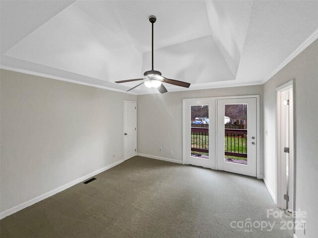 carpeted empty room with a ceiling fan, baseboards, visible vents, lofted ceiling, and crown molding