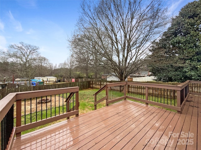 wooden terrace featuring a lawn and a fenced backyard