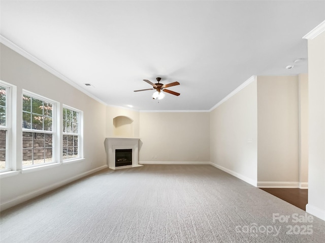 unfurnished living room featuring visible vents, crown molding, baseboards, a fireplace with flush hearth, and carpet floors