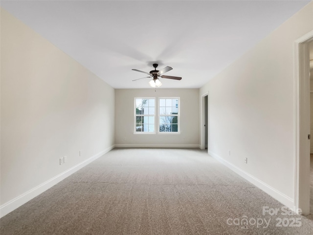 spare room with baseboards, light carpet, and ceiling fan