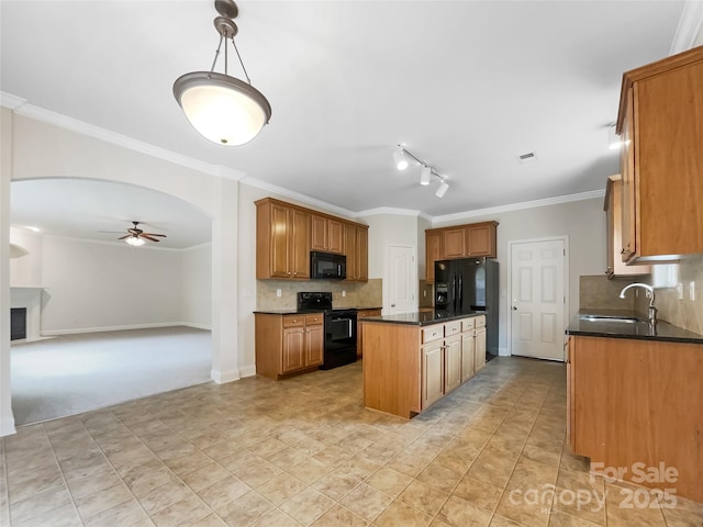 kitchen with black appliances, a sink, dark countertops, a center island, and arched walkways