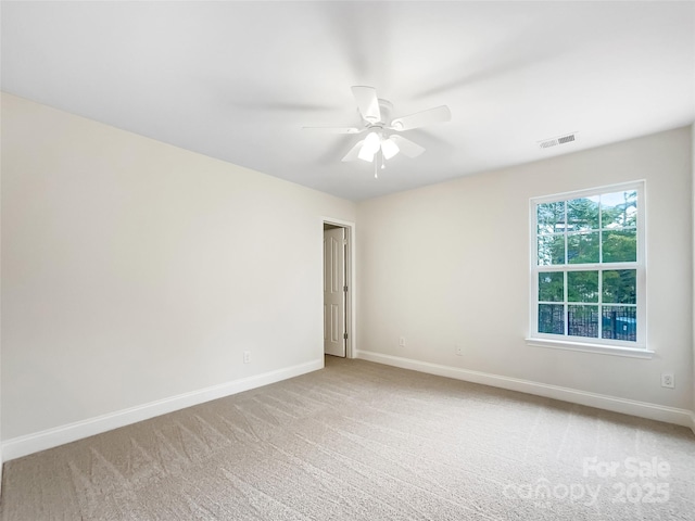 unfurnished room featuring baseboards, visible vents, carpet floors, and ceiling fan