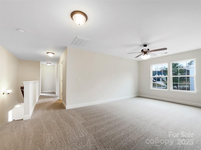 empty room featuring baseboards, visible vents, carpet floors, and ceiling fan