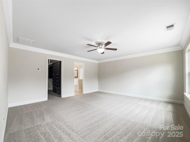 unfurnished room with visible vents, light colored carpet, baseboards, and ornamental molding