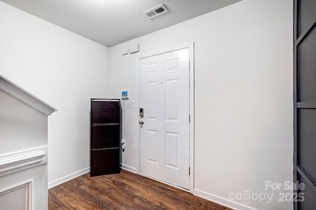 entryway with dark wood finished floors, baseboards, and visible vents