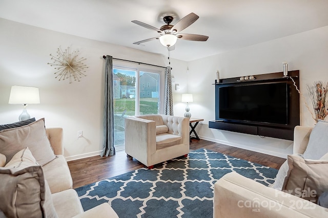 living room featuring a ceiling fan, baseboards, and wood finished floors