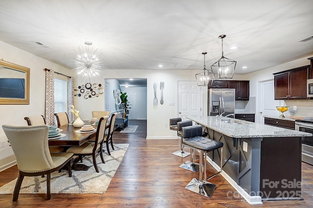 dining area with visible vents, dark wood-style floors, recessed lighting, an inviting chandelier, and baseboards