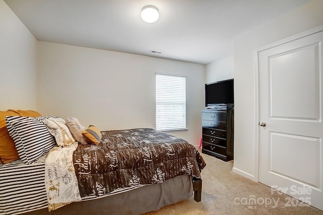 bedroom featuring visible vents and light colored carpet