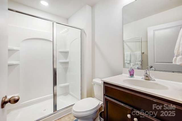 full bath with vanity, toilet, and a shower stall