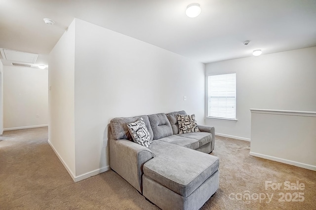 living room featuring light colored carpet, attic access, and baseboards