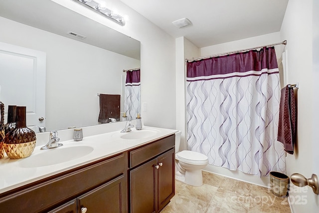 bathroom featuring double vanity, visible vents, toilet, and a sink