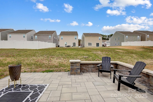 view of patio / terrace featuring fence, a residential view, and an outdoor fire pit