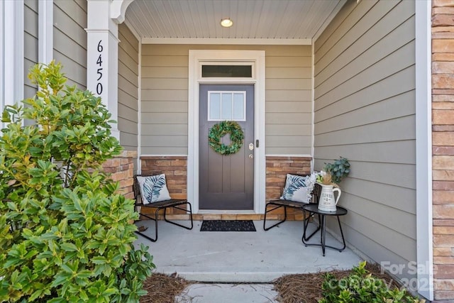 property entrance featuring brick siding and a porch