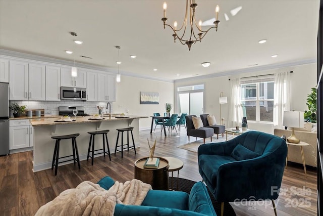 living area with dark wood-style flooring, recessed lighting, and ornamental molding