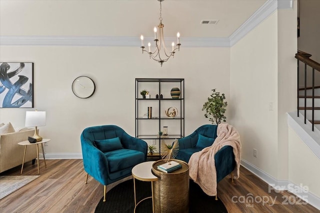 sitting room featuring visible vents, wood finished floors, ornamental molding, and stairs