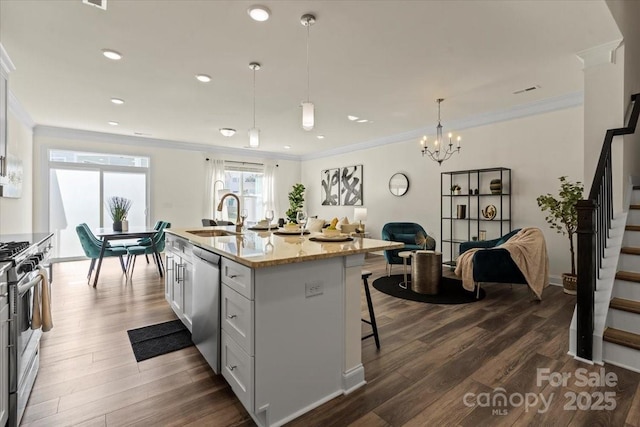 kitchen featuring open floor plan, dark wood-style flooring, stainless steel appliances, and a sink