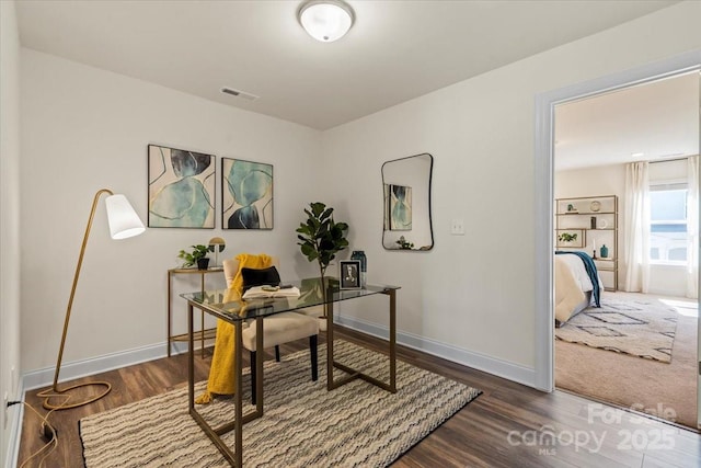 office area featuring visible vents, baseboards, and wood finished floors