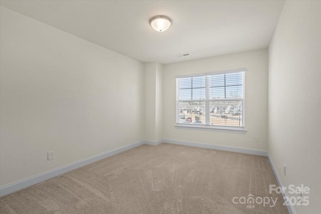 empty room with visible vents, carpet, and baseboards