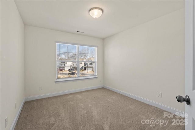 carpeted empty room featuring baseboards and visible vents