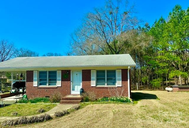 view of front of property with an attached carport, brick siding, and a front yard