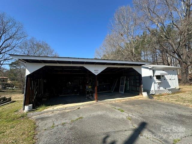 view of pole building with aphalt driveway and a carport