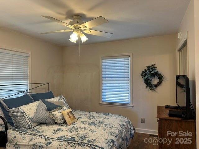 bedroom with wood finished floors, baseboards, and ceiling fan